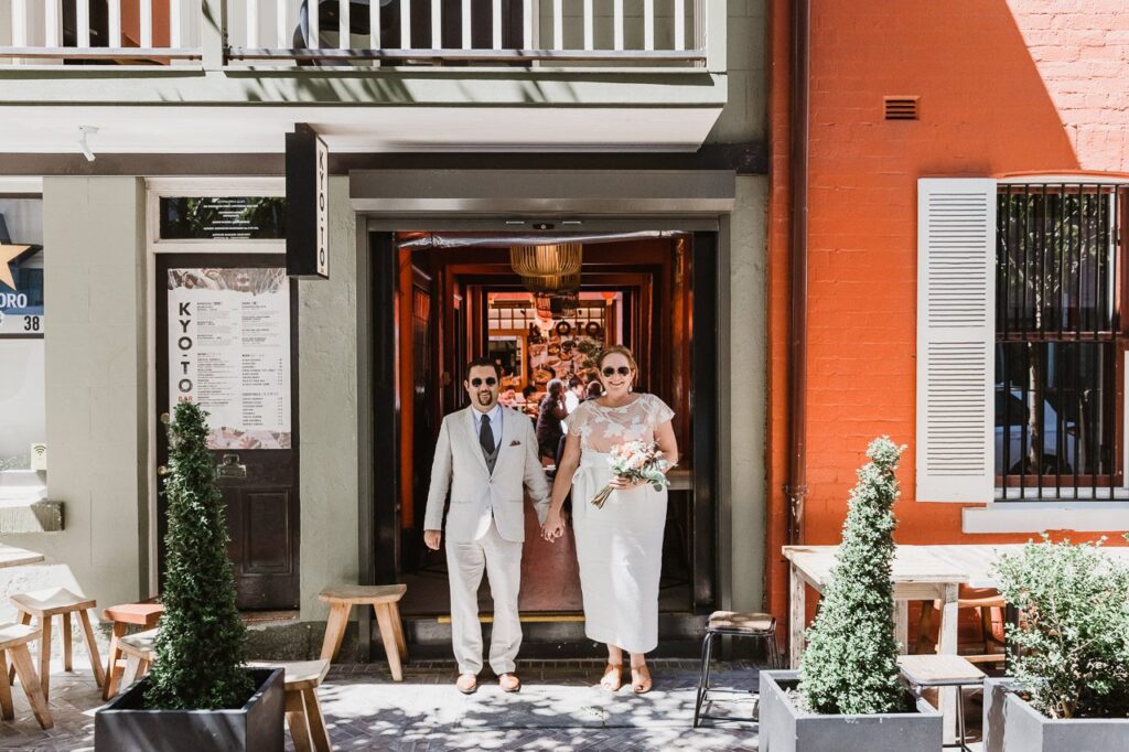 Best places to Elope around Sydney. Urban Elopement ideas. A smiling couple standing in a colourful city street environment. 