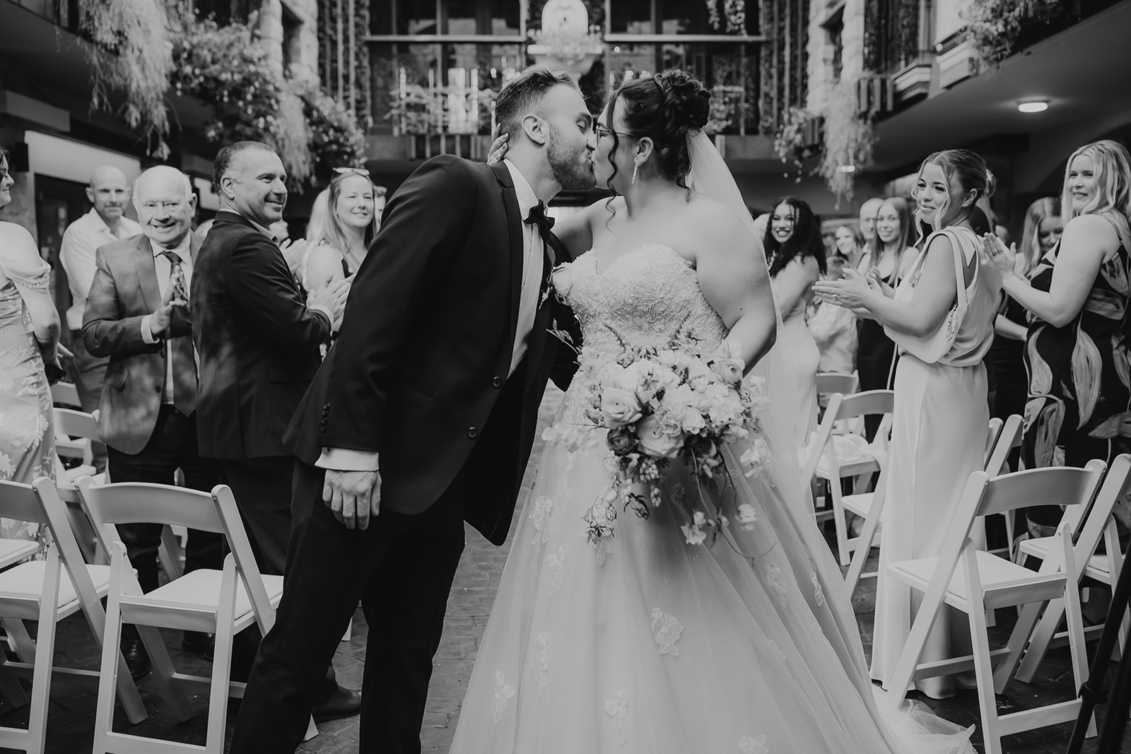 Couple kissing in a piazza on there wedding day