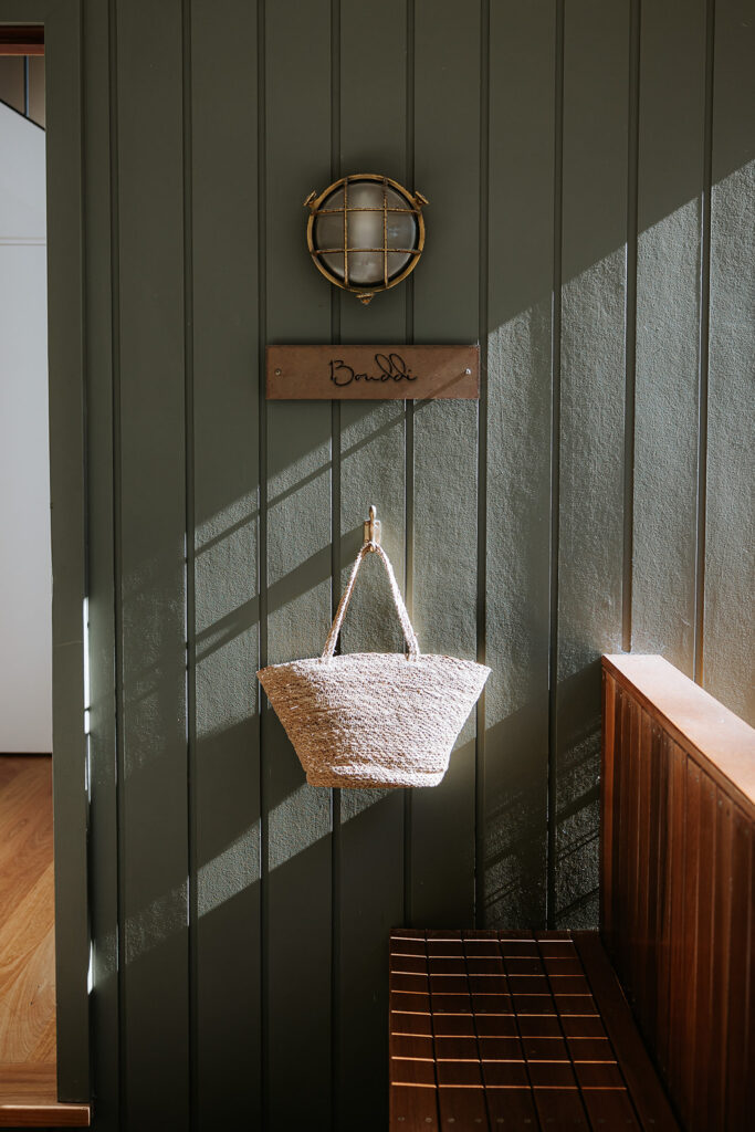 gorgeous panlling with a straw bag hanging styled on the wall