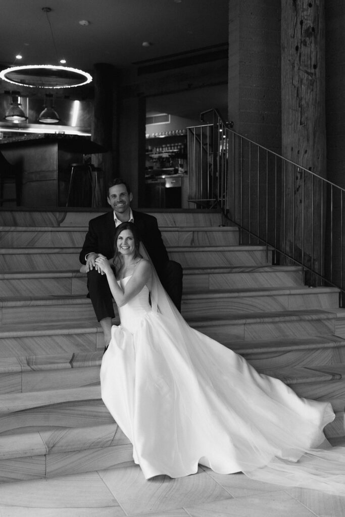Couple on their wedding day sat on the steps inside Pretty Beach House bar. Romantic and editorial style.